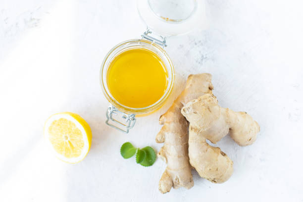 istock Healthy ginger drink in a cup. Ginger root, honey in a jar, lemon on a white table. 1141860720