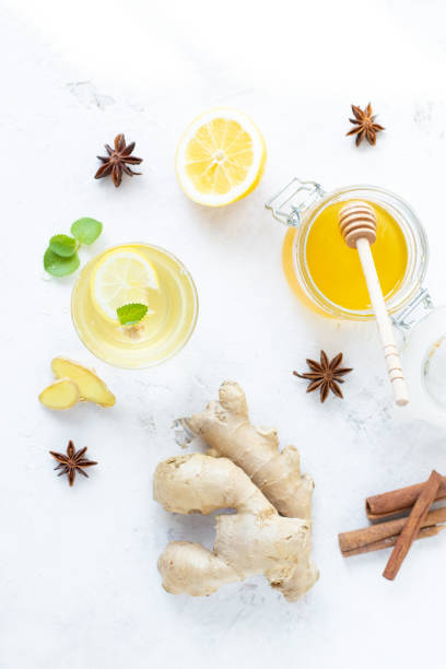 istock Healthy ginger drink in a cup. Ginger root, honey in a jar, lemon on a white table. 1141860726