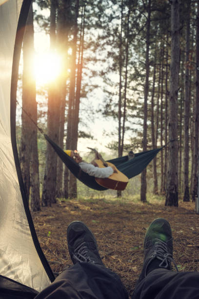 istock Lazy Afternoon Outdoors. Young Woman Tourist Using her Digital Tablet while Swinging in the Hammock. Camping in the Nature. 1141869309