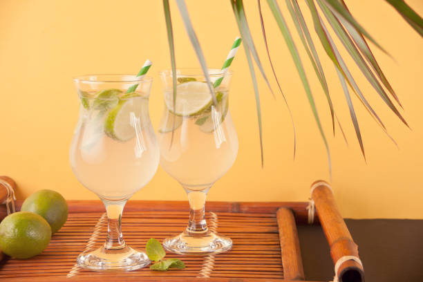 istock Lemonade or mojito cocktail with lemon and mint, cold refreshing drink or beverage on the yellow background. 1141873786