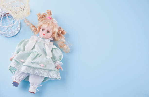 Cute doll on the blue background. Copy space.
