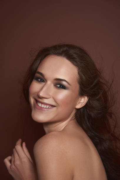 istock Joyful pretty lady posing against brown background 1141874532