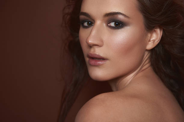 istock Pretty lady with smokey eyes makeup posing against brown background 1141874535