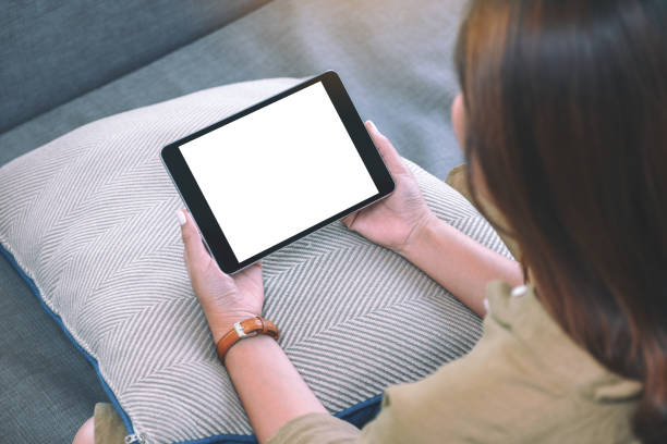 istock a woman holding black tablet pc with blank white desktop screen while sitting in living room 1141877278
