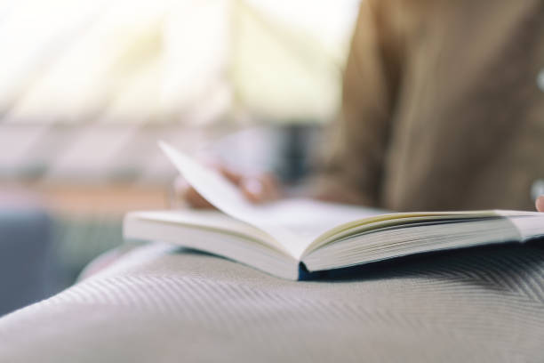 istock a woman opening and reading a book 1141877434