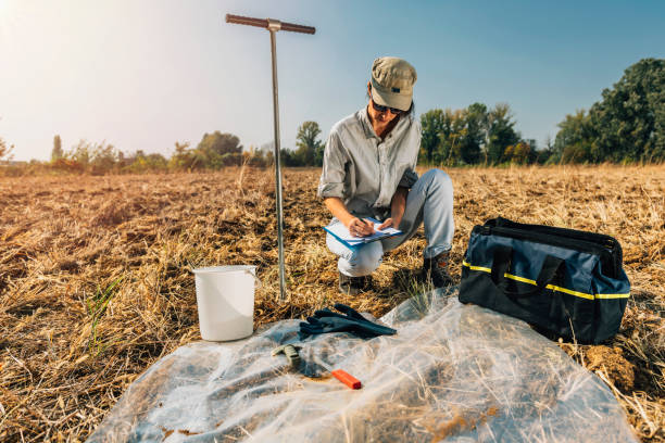 istock Agronomist Writing In Paper While Crouching On Field 1141879951