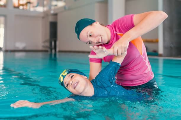 istock Boy Learning To Swim In Pool With Teacher 1141880015