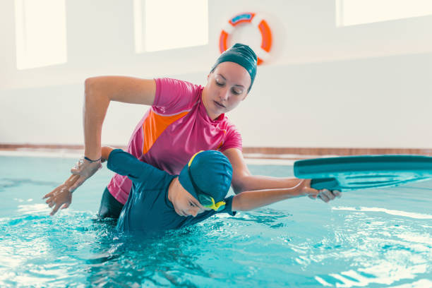 istock Boy Learning To Swim In Pool With Teacher 1141880040