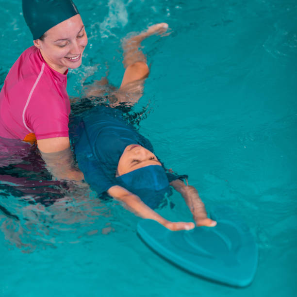 istock Boy Learning To Swim In Pool With Teacher 1141880049