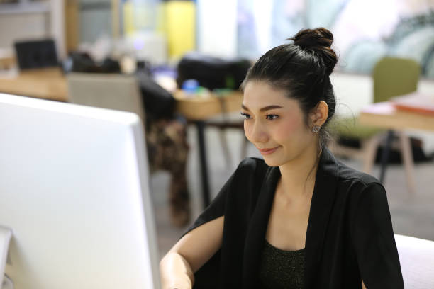 istock Businesswoman Using Computer While Sitting On Desk At Office 1141881581
