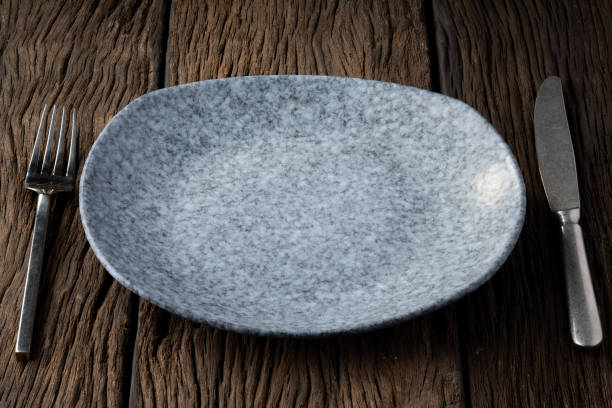 istock plate fork spoon on wood background clear and without depth of field 1141884072