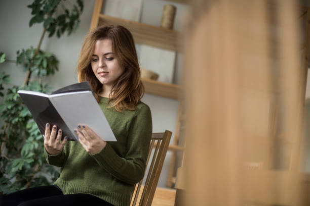 istock Young woman reading a book 1141885899