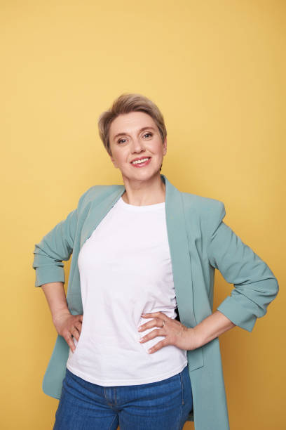 istock Beautiful mother posing in studio against yellow background 1141886601