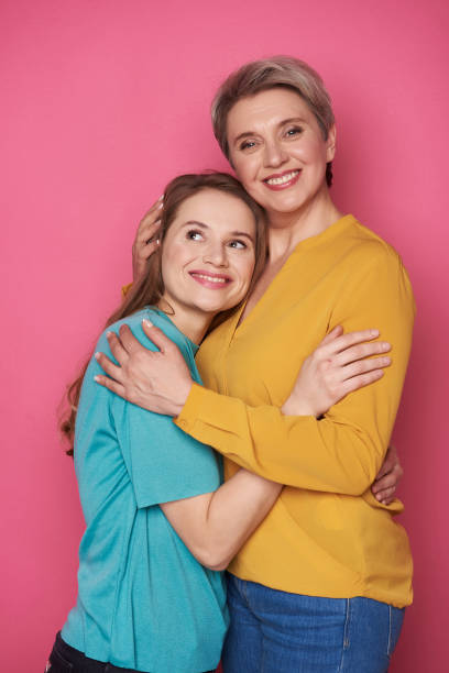 istock Beautiful Caucasian woman is hugging her daughter while looking at camera 1141886834