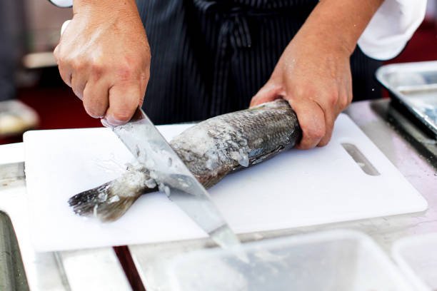 chef at work, chef filleting fish at the kitchen, Chef in restaurant kitchen filleting fish