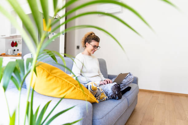 Young woman using laptop online at home