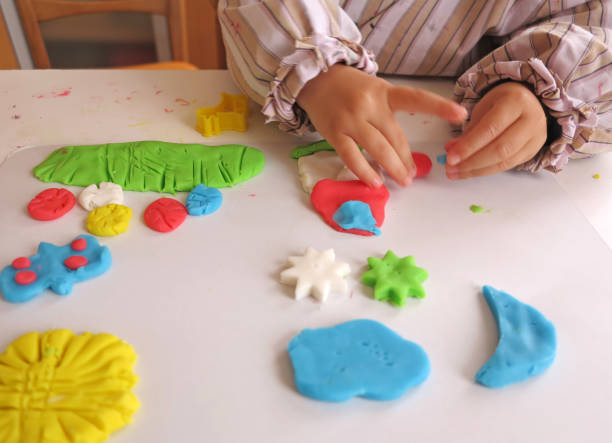istock Hands of a child playing with colorful modelling material or plasticine 1141903281