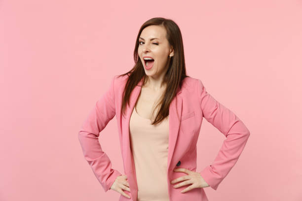 istock Attractive blinking young woman in jacket keeping mouth wide open, standing with arms akimbo on waist isolated on pastel pink background. People sincere emotions lifestyle concept. Mock up copy space. 1141903708