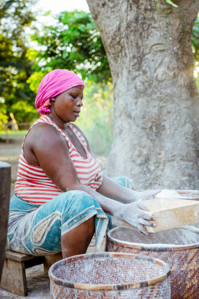 istock African woman sieving cassava flour 1141903717