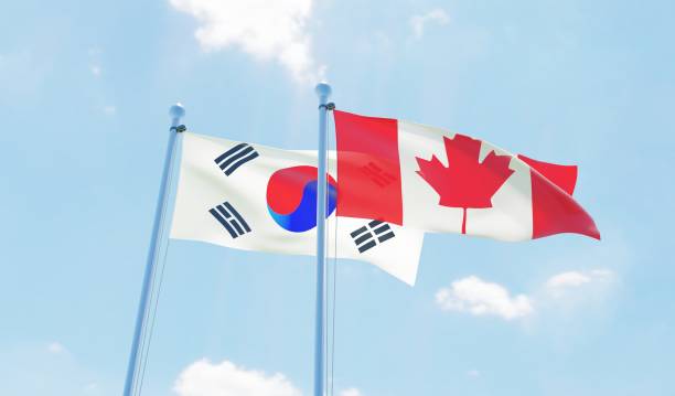 istock Canada and South Korea, two flags waving against blue sky 1141904859