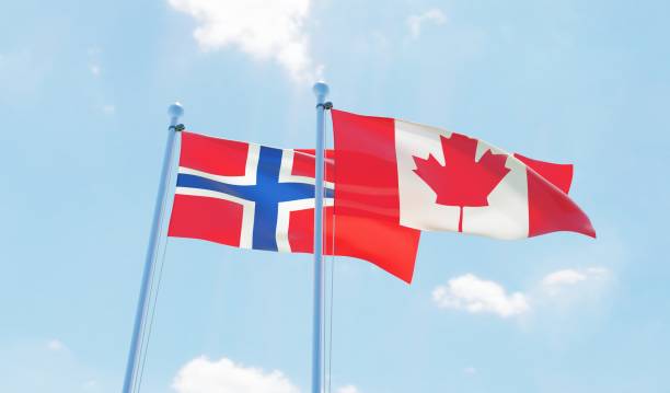 istock Canada and Norway, two flags waving against blue sky 1141905099