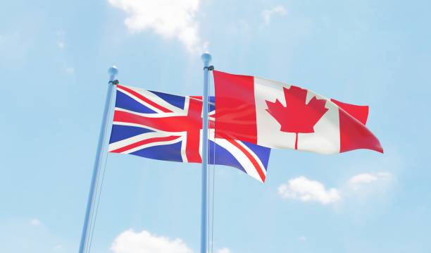 istock Canada and UK, two flags waving against blue sky 1141905236