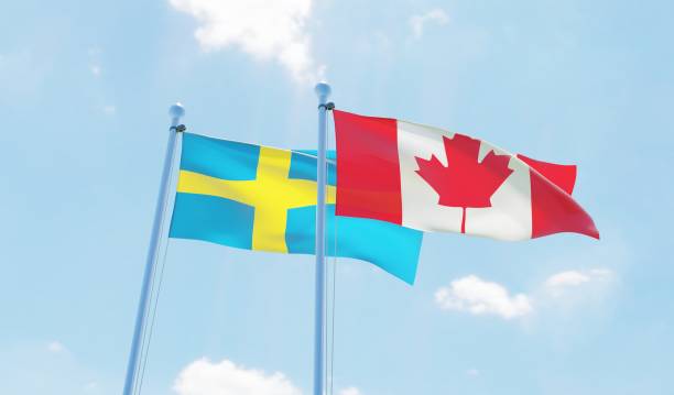 istock Canada and Sweden, two flags waving against blue sky 1141905316