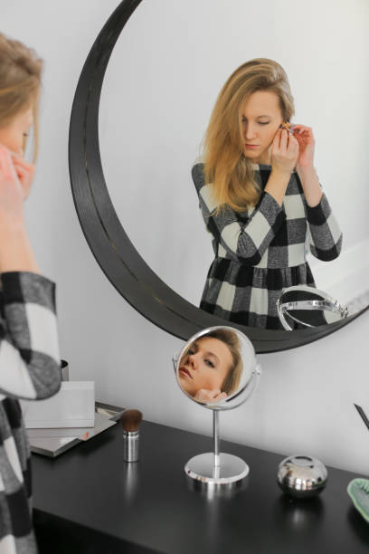 istock serious elegant woman near mirror 1141905446