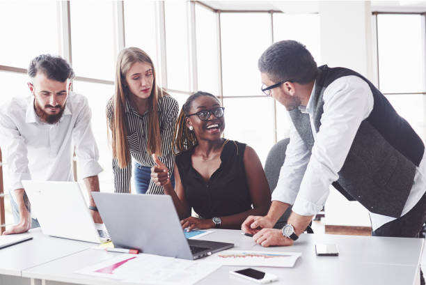 istock That will be easy. Four multiracial employee have work in the office using the laptop on table 1141906528