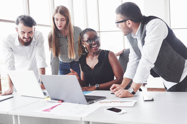 istock Feeling satisfied. Four multiracial employee have work in the office using the laptop on table 1141906547