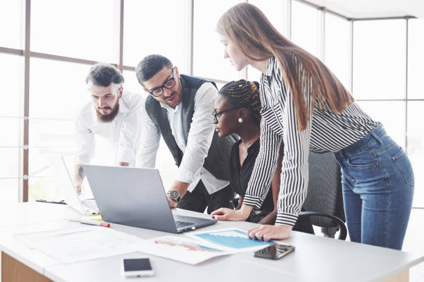 istock Manager in the eyewears talk about plan. Four multiracial employee have work in the office using the laptop on table 1141906596