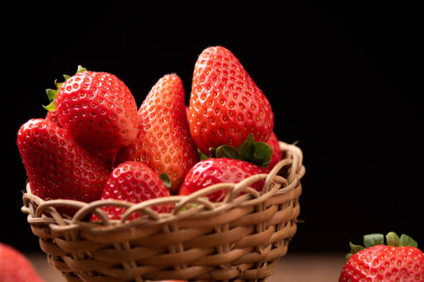 istock Strawberries in a basket on old wooden table 1141909645