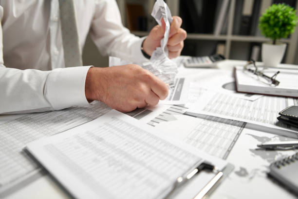 istock Angry businessman has stress and troubles with bad reports, he breaks documents and throws it. 1141909695