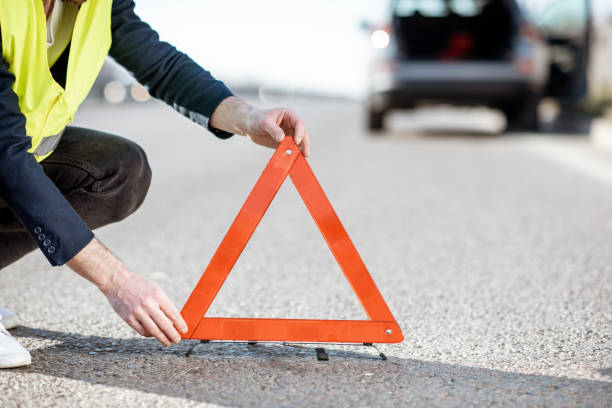 istock Man putting emergency sign on the road 1141910126