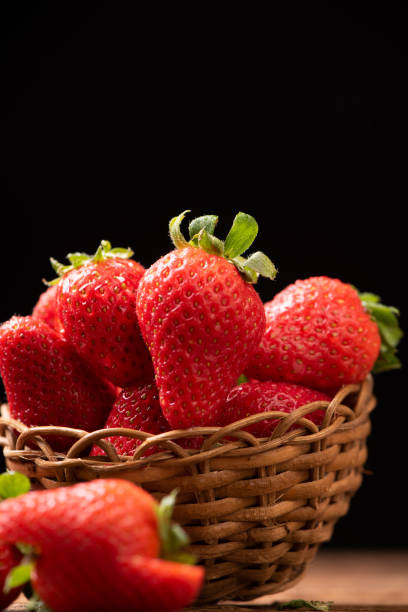 istock Strawberries in a basket on old wooden table 1141910230