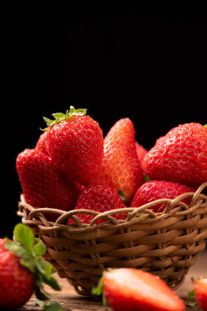 istock Strawberries in a basket on old wooden table 1141910368
