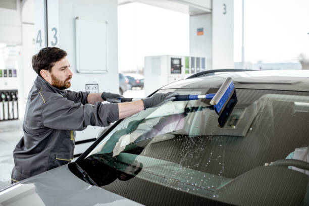 istock Worker washing car windshield at the station 1141910385