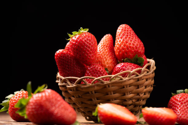 istock Strawberries in a basket on old wooden table 1141910745