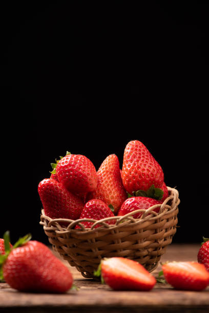 istock Strawberries in a basket on old wooden table 1141910823