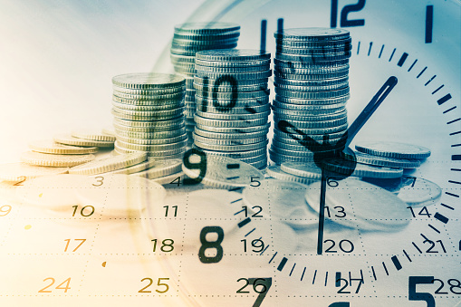 doble exposición de hileras de monedas con reloj y calendario para negocios y fondos de finanzas photo