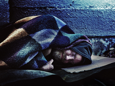 Hombre sin hogar durmiendo en la acera photo