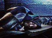 Homeless man sleeping on sidewalk