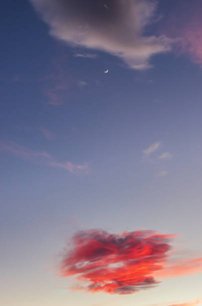 istock Reddish clouds and the moon at sunset over mountains 1141920462
