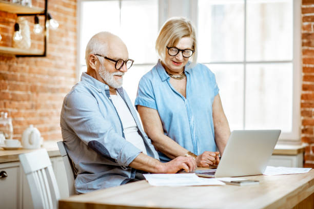 istock Senior couple with laptop at home 1141920724