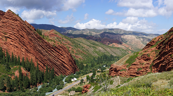 Valley in Jeti-Oguz Gorge  with detail of Seven bulls' red sandstone formation rocks on left.  It is in tourist destination spat, not far from Karakol and eastern part of Lake Issyk-Kul in  Kyrgyzstan.