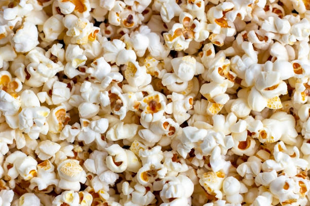 istock Fresh salted popcorn texture background. Close up top view food pattern photography 1141924080