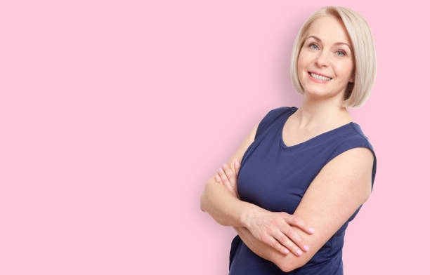istock Happy middle aged woman isolated on pink background 1141925672