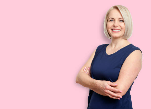 istock Happy middle aged woman isolated on pink background 1141925674