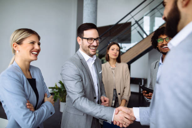 istock Businessmen shaking hands in the office hallway 1141927908