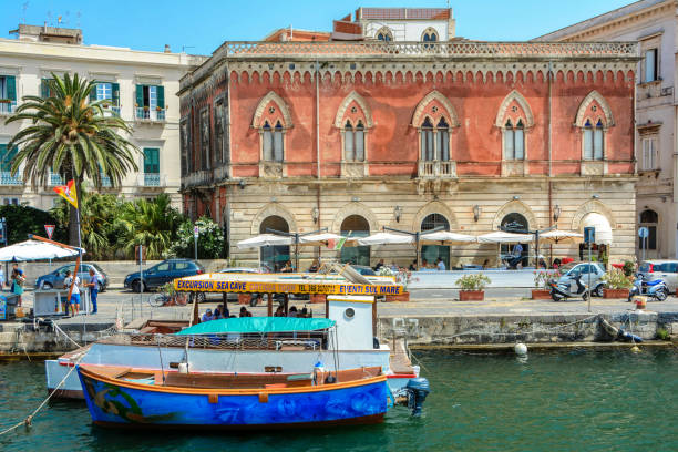 Syracuse, Sicily, Italy - July 2, 2018: Tourists taking a boat trip around the Ortygia Island